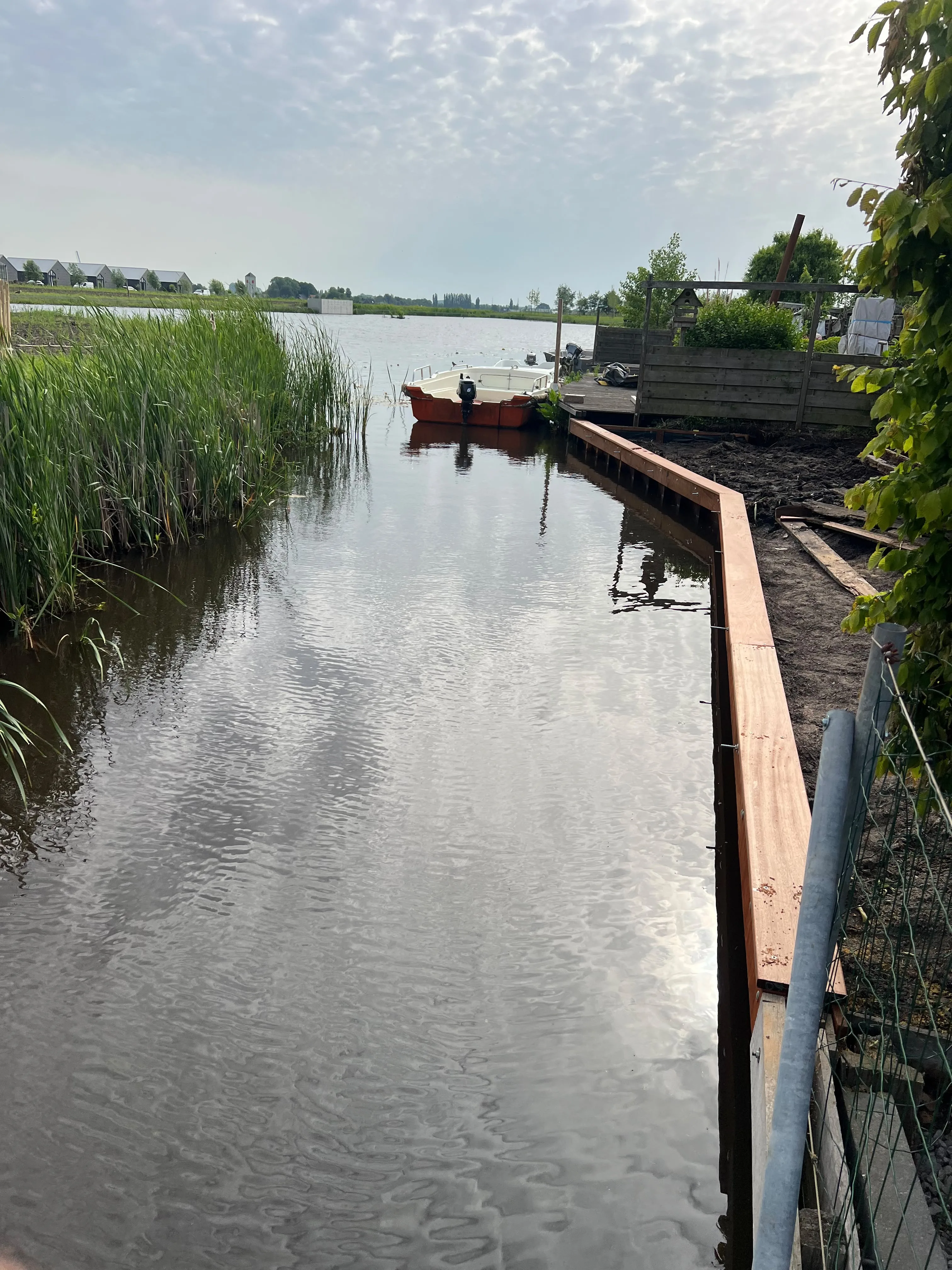 Grondwerk aan het water met minigraver